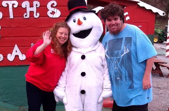 natalie sare standing with a person in a frosty the snowman costume and a young man