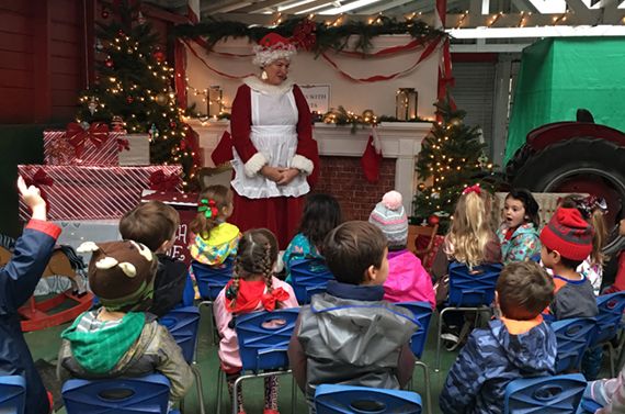 mrs. claus talking to a large group of schoolchildren