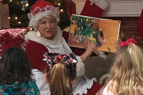 mrs. claus reading to a group of three children
